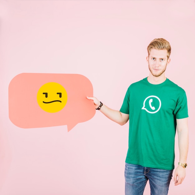 Man holding speech bubble with unhappy emotican