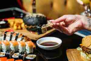 Free photo man holding on sticks maguro maki ginger wasabi side view