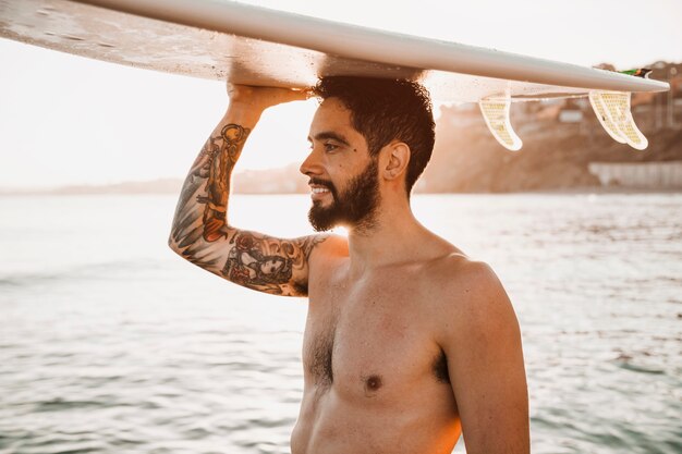 Man holding surfboard on head 