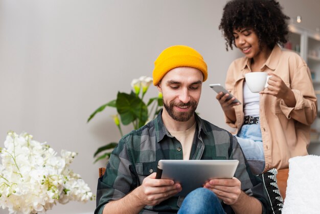 Foto gratuita uomo che tiene un tablet e donna un telefono