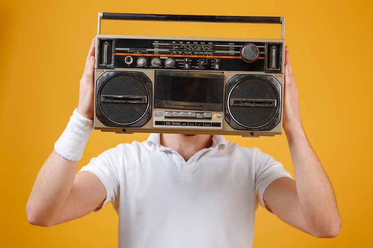 Free Photo man holding tape recorder covering face