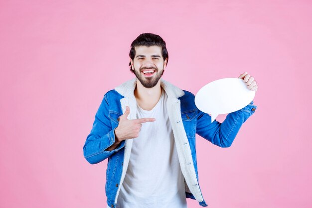 Uomo che tiene in mano una bacheca e la indica