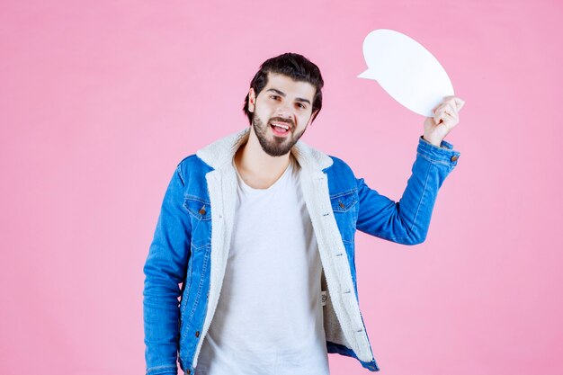 Foto gratuita uomo che tiene in mano una bacheca e la indica