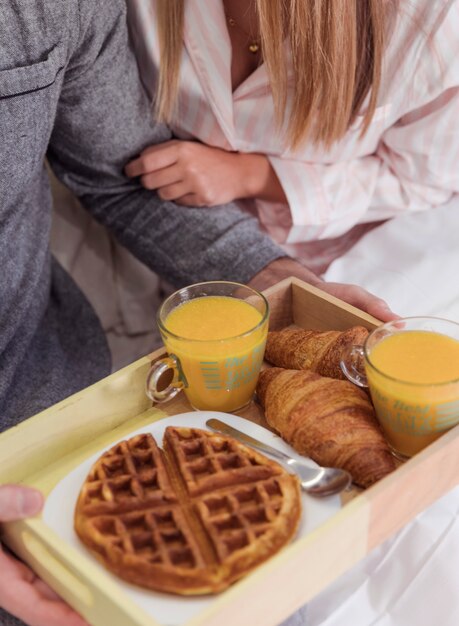 Man holding tray with romantic breakfast in hands 