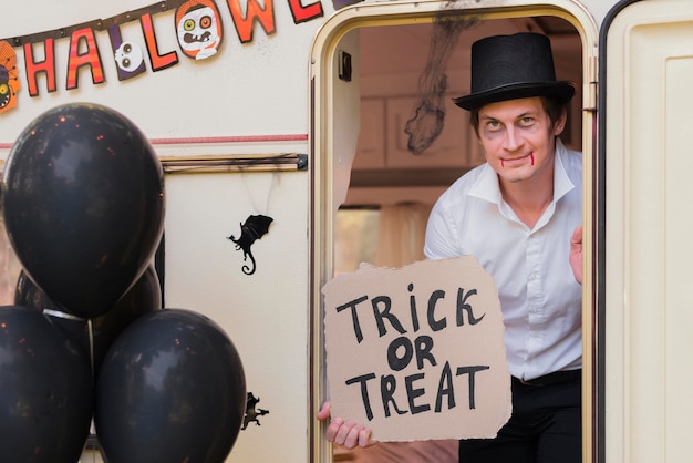 Free photo man holding trick or treat sign