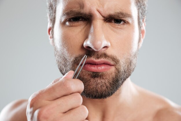 Man holding tweezer and frowning