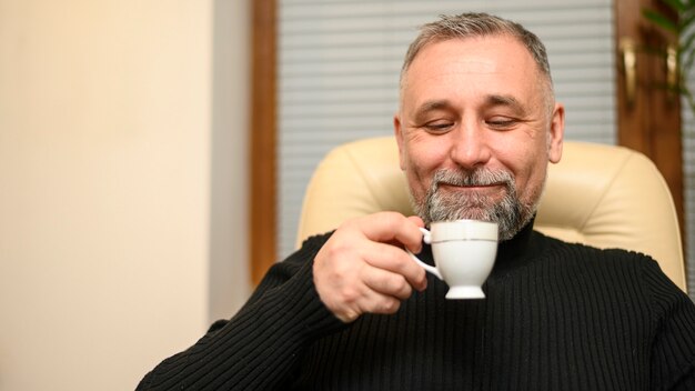 Man holding up a cup of tea