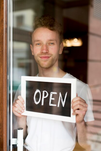 Man holding up open sign