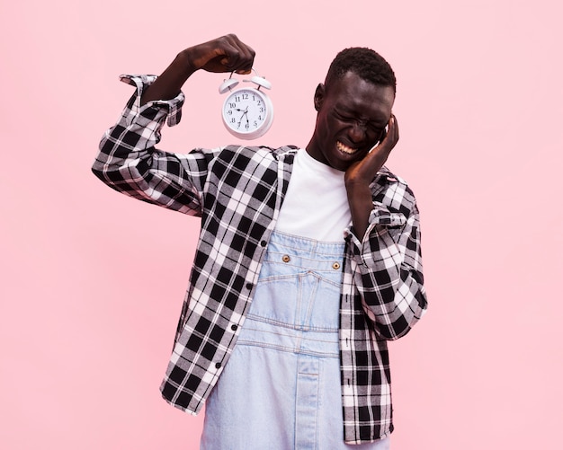 Free photo man holding a vintage clock