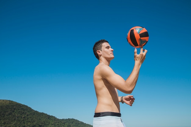 Мужчина держит волейбол с пальцами