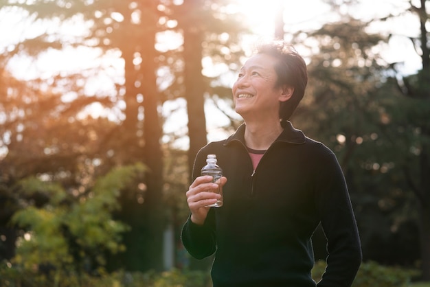 Free photo man holding water bottle medium shot