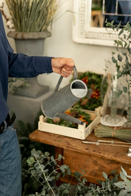 植物に囲まれた水まき缶を抱きかかえた