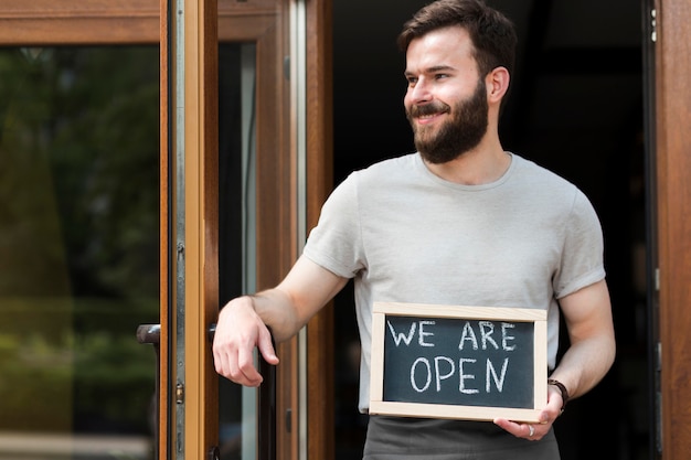 Man holding we are open sign