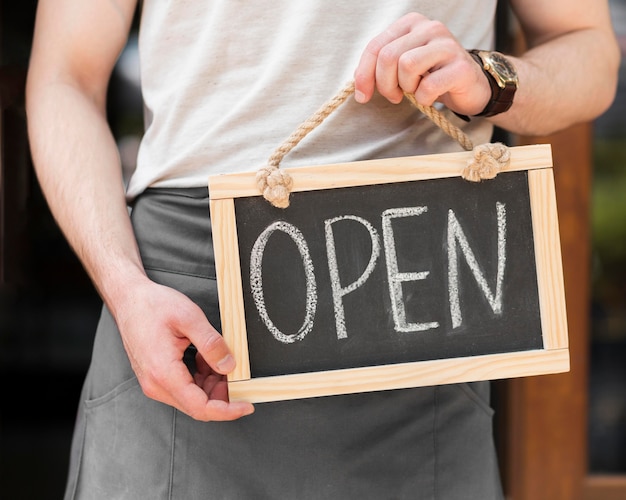 Man holding we are open sign