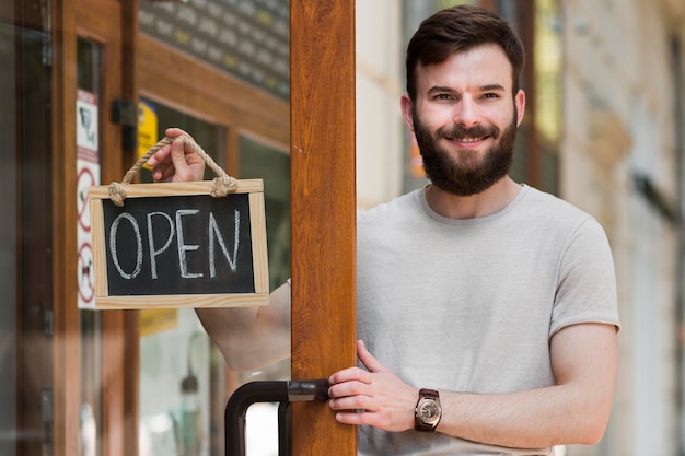 Free photo man holding we are open sign