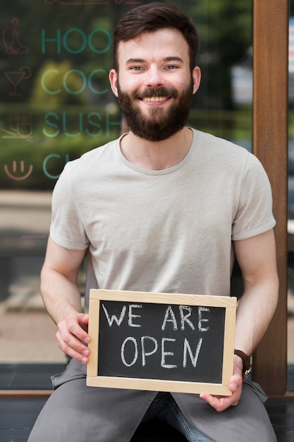 Man holding we are open sign