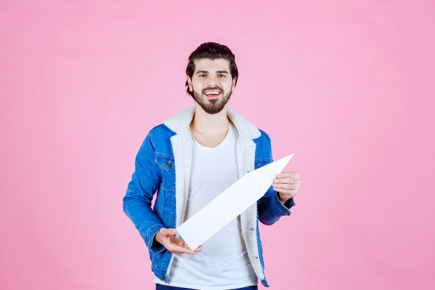 Man holding a white arrow sign pointing to the north east