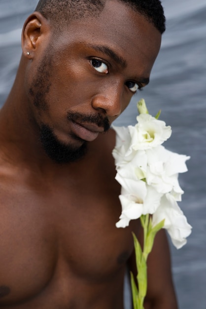 白い花の側面図を保持している男