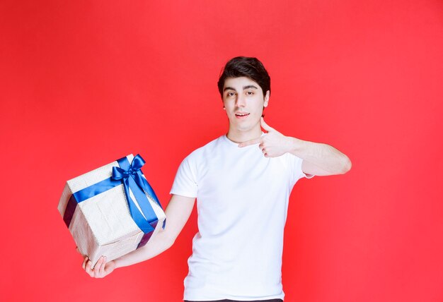 Man holding a white gift box and showing positive hand sign