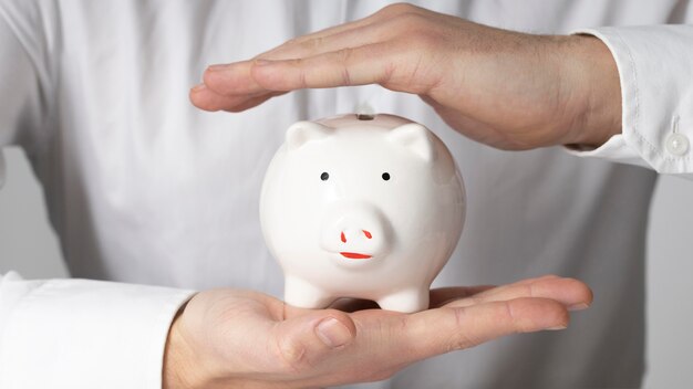 Man holding a white piggy bank