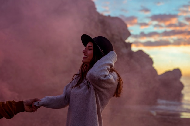 Foto gratuita equipaggi la mano della donna della tenuta sulla riva di mare di sera