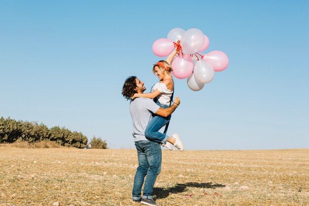 Man holding woman with balloons
