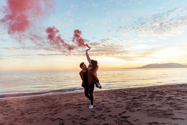 Man holding woman with smoke bomb on back 