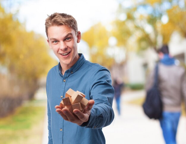 Man holding a wooden intelligence game