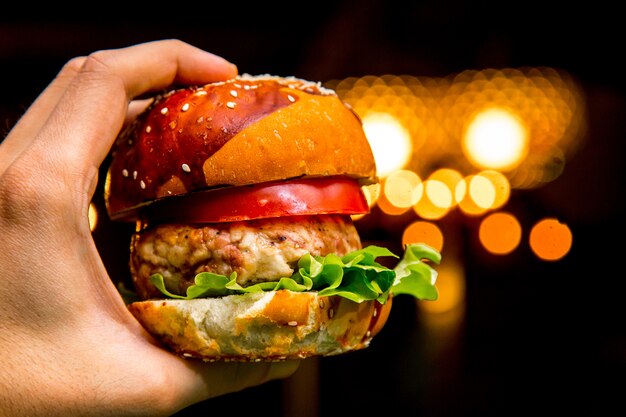 Man holds chicken burger side view