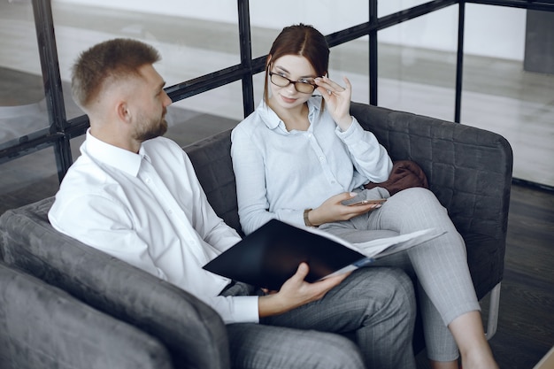 Man holds a folder. Business partners at a business meeting.Woman with glasses