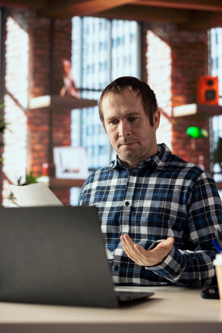 Free Photo man at home office desk using laptop drafting contracts