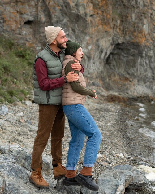 Man hugging girlfriend from behind near sea