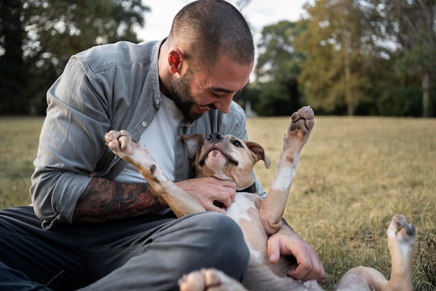 Free photo man hugging his friendly pitbull