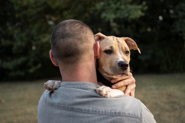 Foto gratuita uomo che abbraccia il suo amichevole pitbull