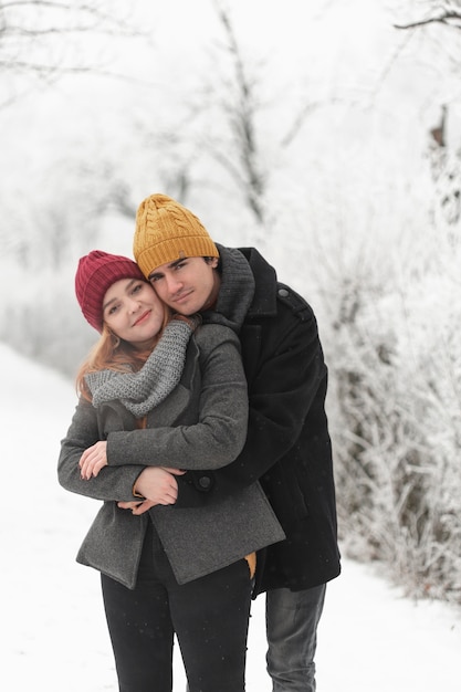 Man hugging his girlfriend outdoors in the snow