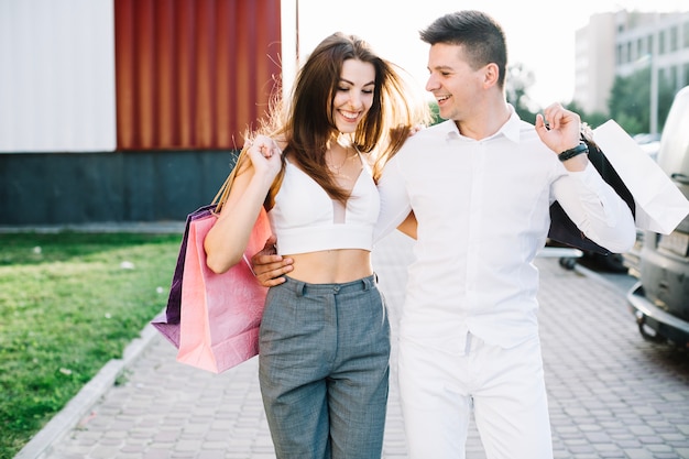 Man hugging his girlfriend walking down street