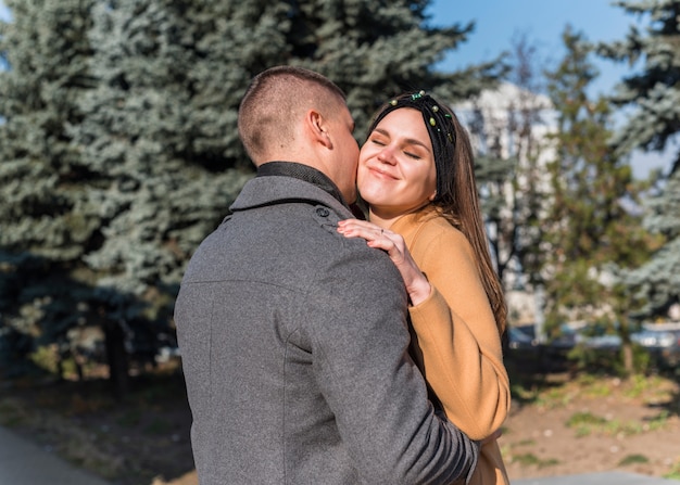 Uomo che abbraccia e bacia la donna sorridente