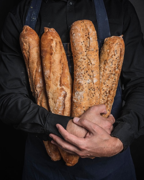 Мужчина обнимает буханки хлеба