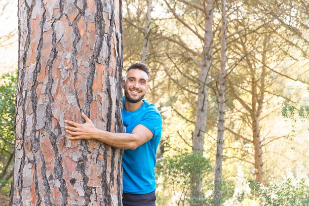 Man hugging tree in lovely forest