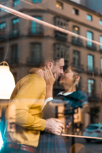 Foto gratuita equipaggi abbracciare con la donna felice vicino alla finestra del ristorante
