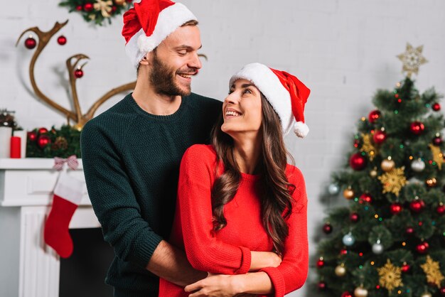 Man hugging woman in Christmas hat