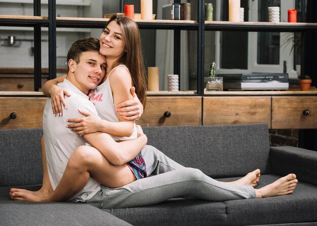 Man hugging woman on couch 