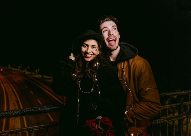 Man hugging woman from behind on bridge 