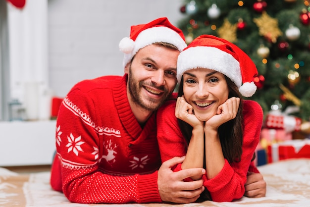 Man hugging woman near Christmas tree