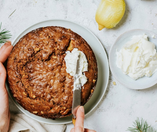 Man icing a carrot cake using a knife