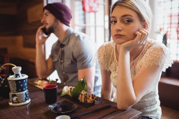 Man ignoring woman while talking on phone