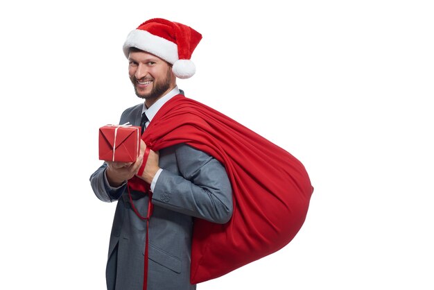 Бесплатное фото Человек в сером люксе, как санта-клаус, дающий коробку с подарком