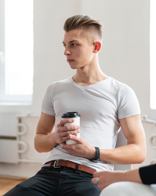 Бесплатное фото Человек в терапии, держа чашку кофе