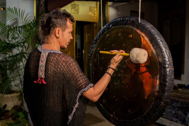 A man is practicing a sound gong