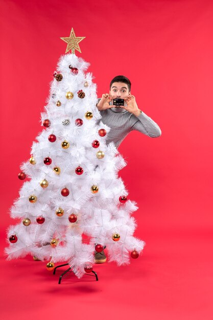 クリスマスツリーの横に男が立っています